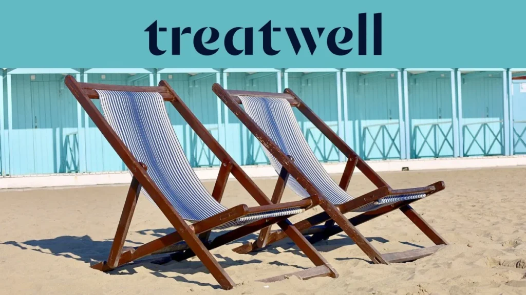 Two striped wooden deckchairs on the sand in front of pastel-blue beach huts on the Versilia coast